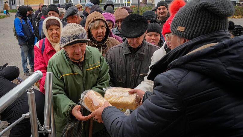 Die Anwohner von Bachmut stehen in einer Schlange, um kostenloses Brot von Freiwilligen zu erhalten.