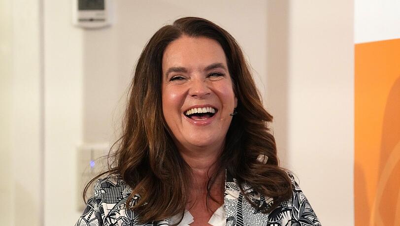 Katarina Witt, Eiskunstlauf-Olympiasiegerin lacht.