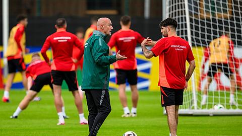 Trainer Marco Rossi (l) spricht mit Dominik Szoboszlai beim Training der ungarischen Nationalmannschaft.