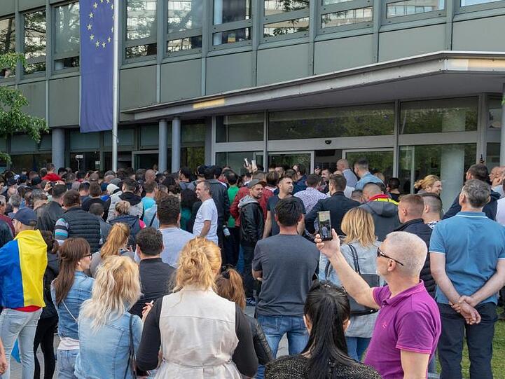 Rumänische Staatsangehörige stehen vor dem rumänischen Konsulat, um ihre Stimme für die Europawahl abzugeben. Foto: Peter Kneffel