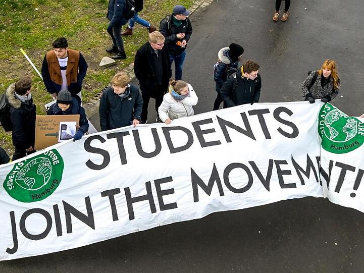Teilnehmer der Klima-Demonstration von Fridays for Future tragen ein Transparent mit der Aufschrift "Students join the movement".