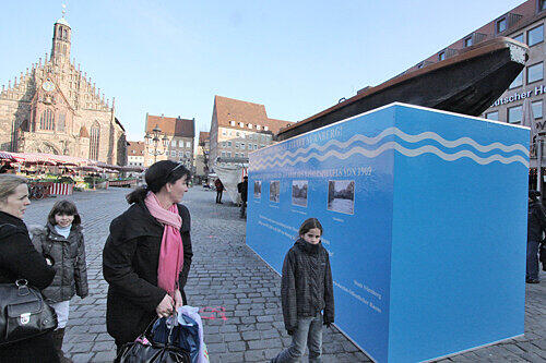 Soll an die Flut erinnern: Am Hauptmarkt steht derzeit eine Box, auf der ein Kahn in Höhe des Hochwasserstands von 1909 montiert ist.