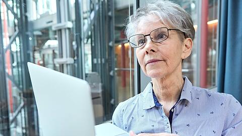 Eine Seniorin arbeitet am Laptop im Unternehmen. Man muss über eine längere Lebensarbeitszeit diskutieren dürfen, sagt vbw-Vize Bertram Brossardt.