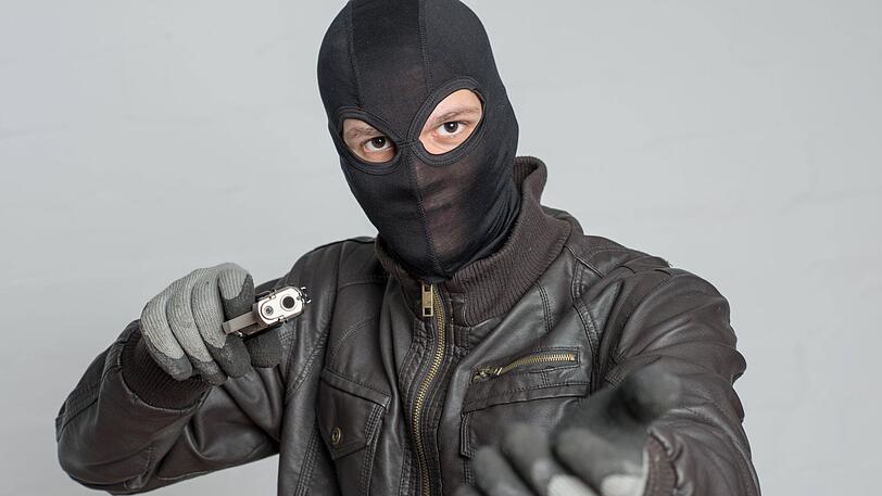 Der maskierte Täter hat mit einer Pistole bewaffnet einen Pizza-Lieferdienst überfallen. (Symbolbild)