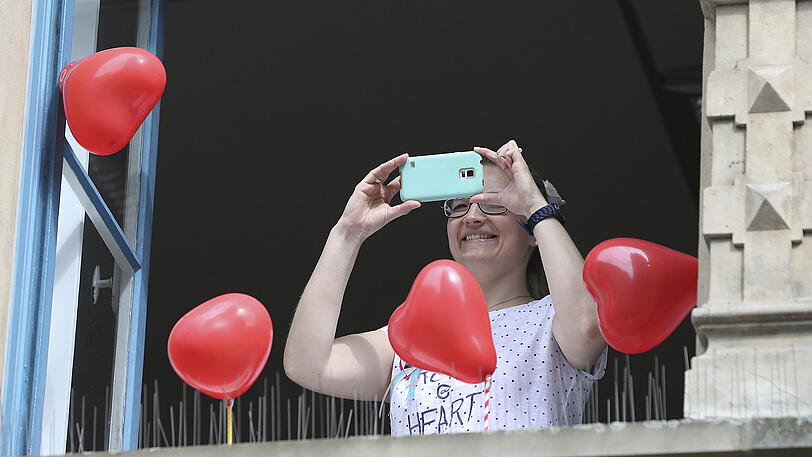 Eine Frau fotografiert aus ihrem Fenster gegenüber der Marktkirche in Hannover.