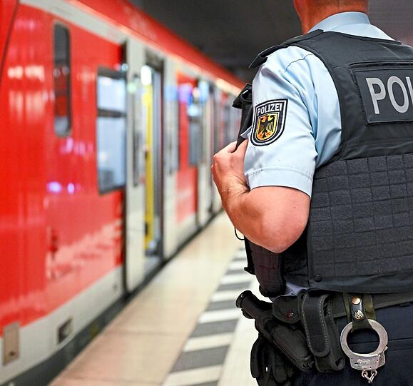 Ein Bundespolizist steht am Hauptbahnhof München an einer S-Bahn.