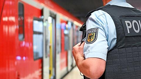 Ein Bundespolizist steht am Hauptbahnhof München an einer S-Bahn.