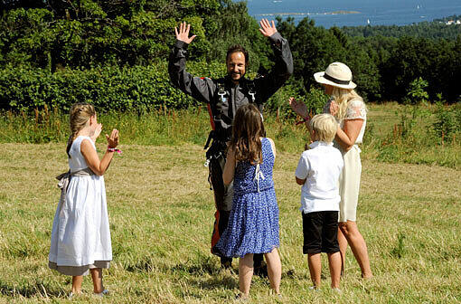 Fallschirmspringer Haakon wird im Garten der königlichen Residenz von seiner Famlie begrüßt.