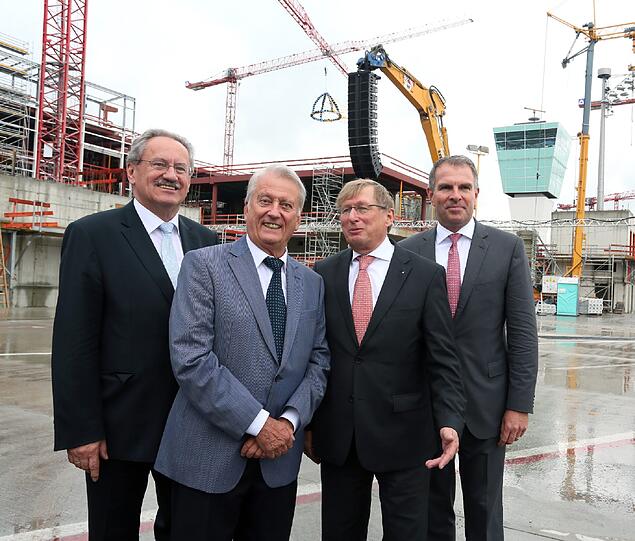 Ob Christian Ude, Architekt Norbert Koch, Flughafen-Chef Michael Kerkloh und Lufhansa-Vorstandsmitglied Carsten Spohr freuen sich beim Richtfest über die bisher reibungslosen Bauarbeiten.