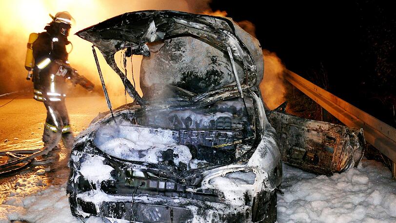 Ein Feuerwehrmann steht am 24.11.2013 neben einem ausgebrannten Autowrack auf der Autobahn A7 bei Hildesheim (Niedersachsen) Ein Feuerwehrmann steht am 24.11.2013 neben einem ausgebrannten Autowrack auf der Autobahn A7 bei Hildesheim (Niedersachsen)