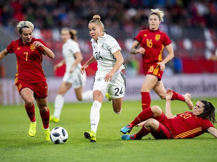 Giulia Gwinn (M) setzt sich mit dem Ball gegen gegen Spaniens Marta Corredera Rueda (l) und Andrea Pereira Cejudo durch.