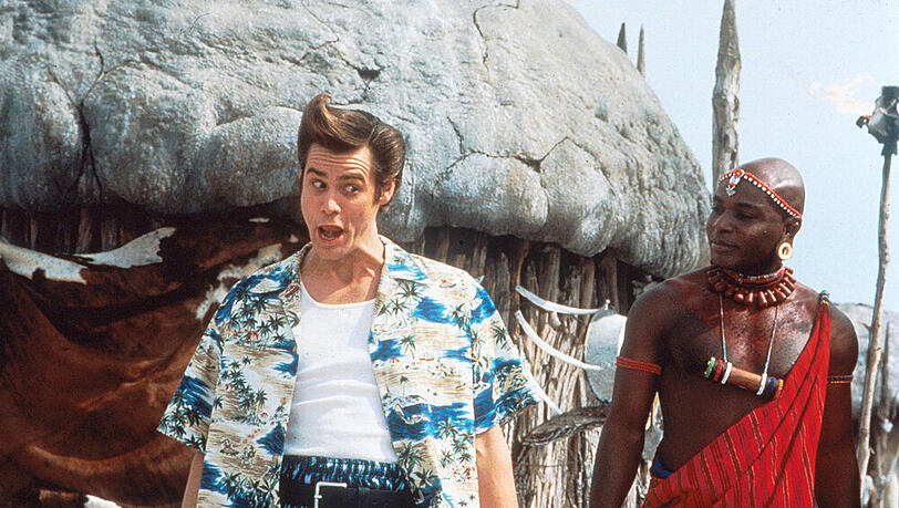 Ace Ventura (Jim Carrey, l.) und Stammesmitglied Ouda - zwei Kulturen treffen aufeinander. Ace Ventura (Jim Carrey, l.) und Stammesmitglied Ouda - zwei Kulturen treffen aufeinander.