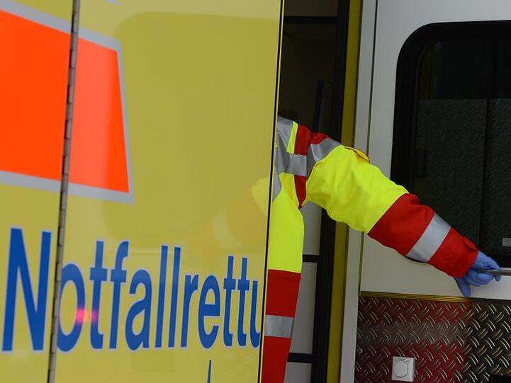 Ein Rettungsassistent steigt in einen Rettungswagen. Foto: Jens Kalaene/Archivbild