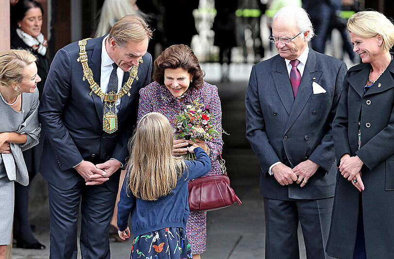 Blumenmädchen Elin Fornhammar überreicht Königin Silvia von Schweden (M) einen Blumenstrauß, daneben König Carl XVI. Gustaf (2.v.r) und die schwedische Sozialministerin Asa Regner (r) sowie Leipzigs OBM Burkhard Jung (SPD, 2.v.l) und Frau Ayleena (l).