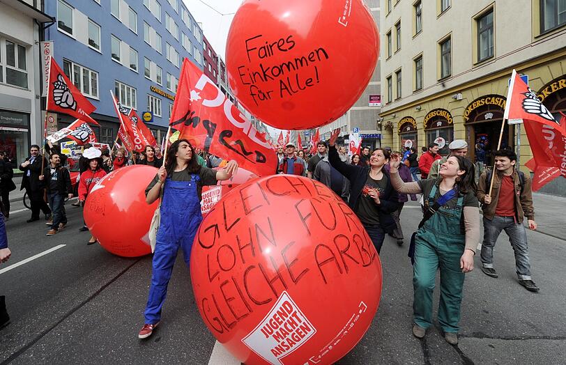 Demonstranten werfen und rollen am 01. Mai 2013 in der Münchner Innenstadt rote, mit Sprüchen beschriebene Bälle.