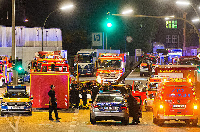 Einsatzkräfte der Feuerwehr und Polizei stehen in Hamburg-Billbrook vor einer Chemiefirma.