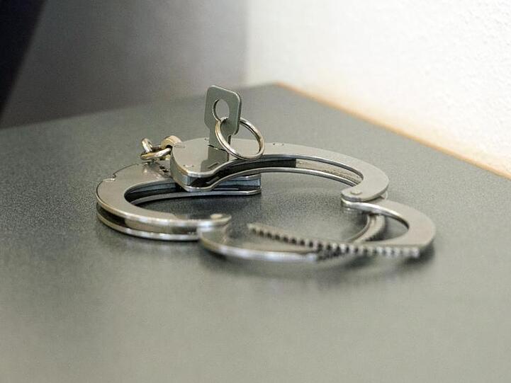 Handschellen liegen auf einem Tisch. Foto: Armin Weigel/dpa