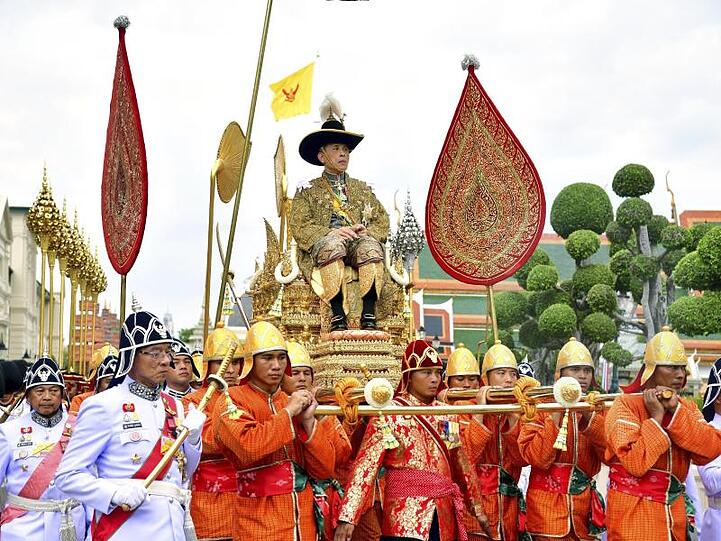 König Maha Vajiralongkornwird auf einer Sänfte durch die Straßen getragen. Er ist der zehnte König seit Beginn der Chakri-Dynastie 1782 und trägt auch den Namen Rama X.
