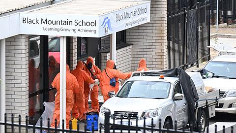 In Schutzanz&uuml;gen wurden die Schulen ges&auml;ubert und der Sand entsorgt.