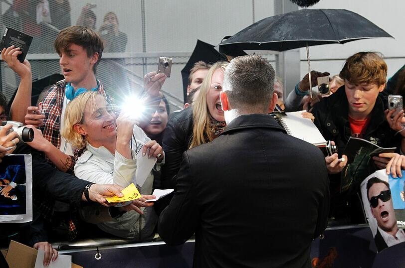 Weltstar im Fan-Gewusel: Robbie Williams verteilte Autogramme vor dem Mathäser-Kino.
