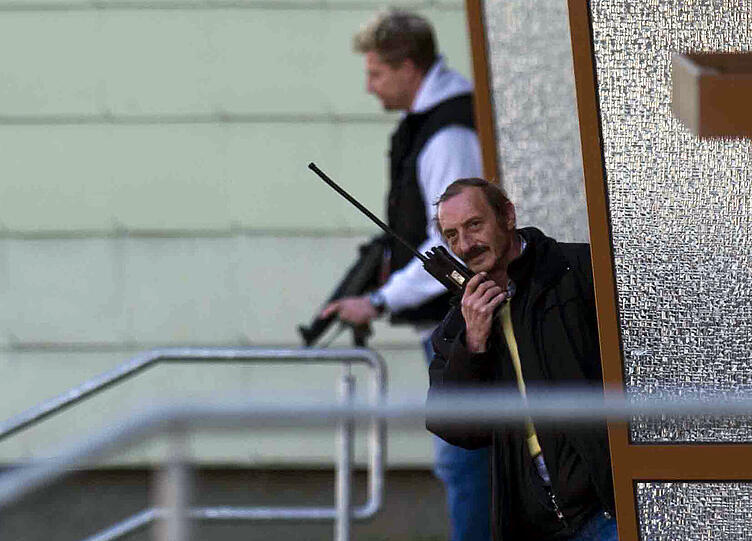 Ein Polizist mit Funkgerät steht am Dienstag im Eingang eines Hauses in Bad Langensalza.