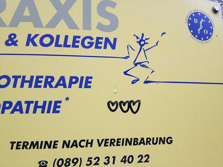 Das Schild dieser Krankengymnastik-Praxis ist hellgelb - und hat auch drei Herzl aufgemalt gekriegt!