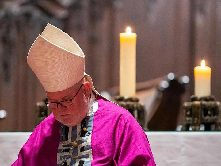 Kardinal Reinhard Marx, Vorsitzender der Bischofskonferenz, sitzt bei einem Gottesdienst in einem Dom. Foto: Andreas Arnold/dpa/Archivbild