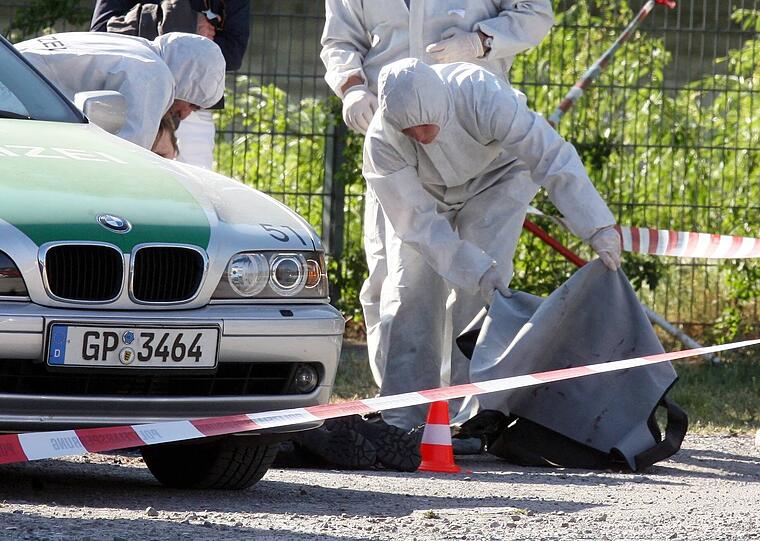Beamte der Spurensicherung der Polizei arbeiten am 25.04.2007 auf der Heilbronner Theresienwiese an einem Tatort, an dem zuvor eine Polizeibeamtin getötet und ein weiterer Beamter schwer verletzt wurde.