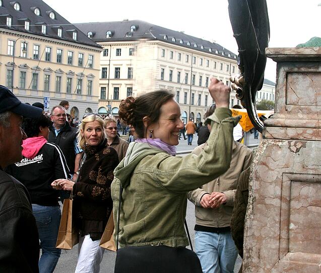 Stadtführerin Kathrin reibt an den Löwen vor der Residenz. Das soll Glück bringen.