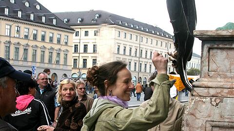 Stadtführerin Kathrin reibt an den Löwen vor der Residenz. Das soll Glück bringen.