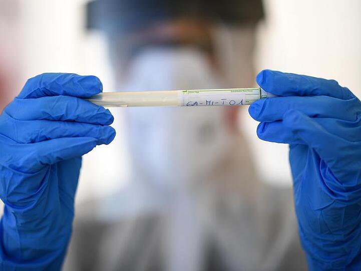 Mitarbeiter vom Gesundheitsamt hält ein Test-Kit. Foto: Britta Pedersen/dpa-Zentralbild/dpa/Archivbild