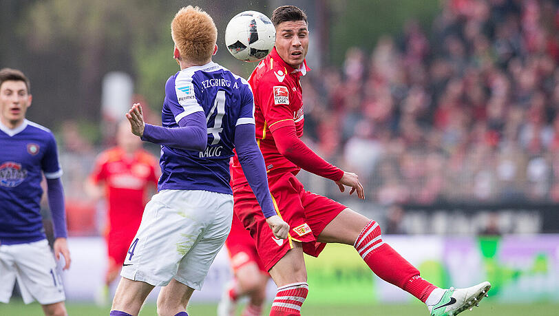 Unions Damir Kreilach springt im Duell mit Aues Fabian Kalig (4) zum Ball.