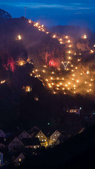 Beeindruckende Bilder: Zahlreiche Besucher stehen am Samstag nahe der Burg Pottenstein in der Stadt Pottenstein und blicken auf hunderte Bergfeuer. Grund ist das katholische Fest der Ewigen Anbetung.