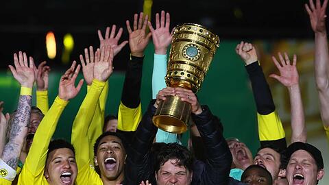 BVB-Coach Edin Terzic streckt den DFB-Pokal in den Berliner Nachthimmel.