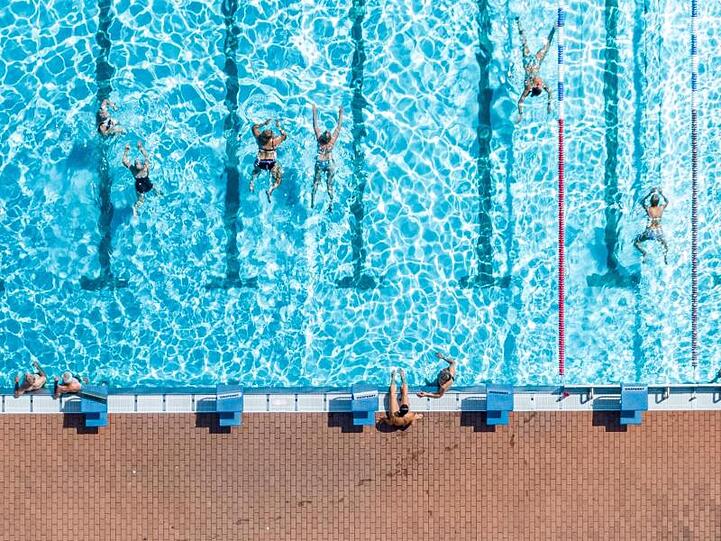 Badegäste schwimmen im Freibad Aquatherm in Straubing im Wasser. Foto: Armin Weigel