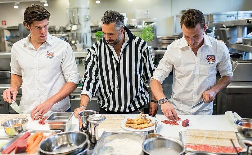 Zweikampf am Herd: EHC-Spieler Alexander Barta gegen den Salzburger Matthias Trattnig. In der Mitte: Koch-Referee Roland Trettl.