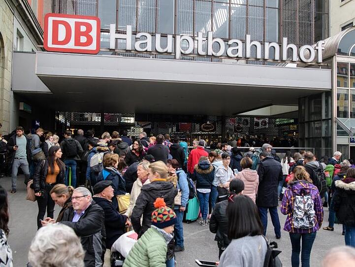 Zahlreiche Reisende warten vor dem abgesperrten Hauptbahnhof. Foto: Matthias Balk/Archiv