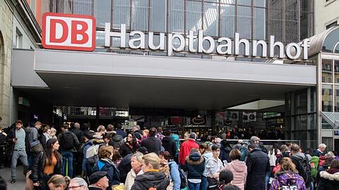 Zahlreiche Reisende warten vor dem abgesperrten Hauptbahnhof. Foto: Matthias Balk/Archiv