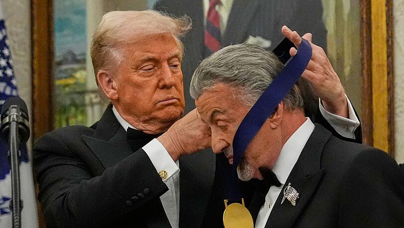 US-Präsident Donald Trump hängt der Actionfilm-Ikone Sylvester Stallone eine Medaille um. US-Präsident Donald Trump hängt der Actionfilm-Ikone Sylvester Stallone eine Medaille um.
