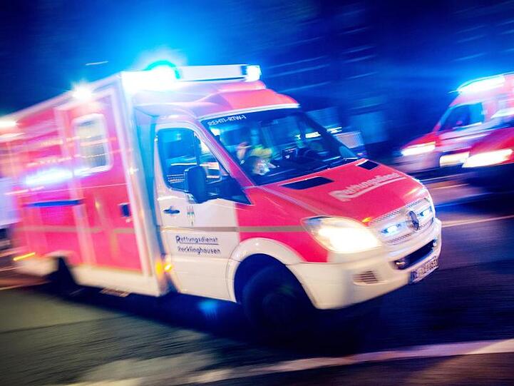 Ein Rettungswagen der Feuerwehr fährt mit Blaulicht durch eine Straße. Foto: Marcel Kusch/dpa/Illustration