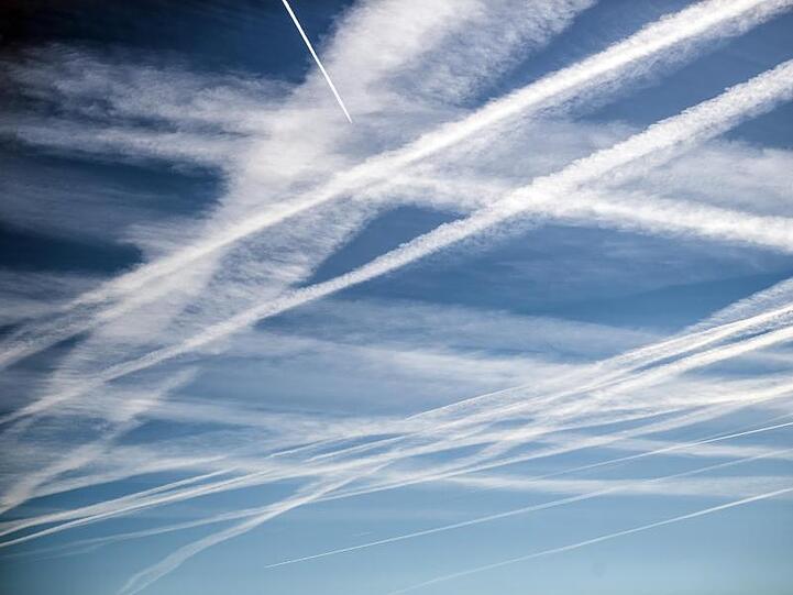 Die Kondensstreifen zahlreicher Flugzeuge am Himmel über Köln.