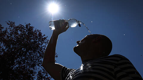 Ein Mann l&auml;sst sich zur Erfrischung Wasser &uuml;ber das Gesicht laufen. Die Hitzewelle ist bald vorbei.
