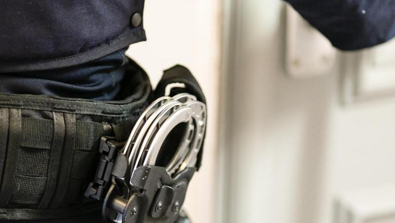 Handschellen sind an einem Gürtel eines Justizvollzugsbeamten befestigt.