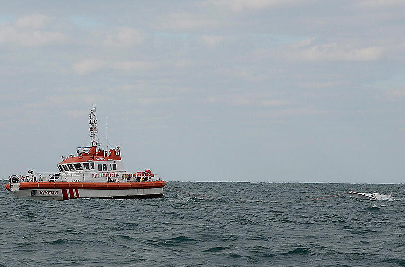 Ein Rettungsschiff schleppt das Wrack des Flüchtlingsboots hinter sich her. Mindestens 40 Menschen sollen an Bord gewesen sein.
