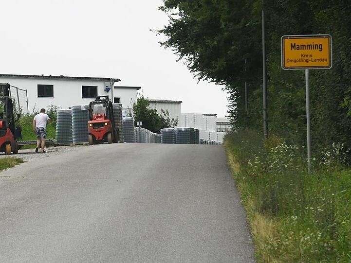 Arbeiter errichten eine Zaun um die Wohngebäude eines Betriebes in Mamming.