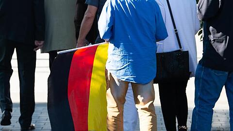 Ein Teilnehmer des "Flügel"-Treffens mit einer Deutschland-Flagge.