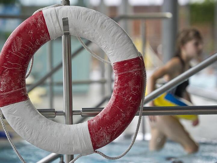 Ein Kind mit Schwimmring geht am Geibeltbad an einem Rettungsring vorbei. Foto: Ole Spata/Archivbild