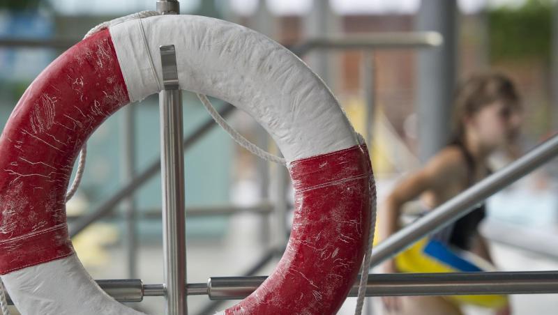 Ein Kind mit Schwimmring geht am Geibeltbad an einem Rettungsring vorbei. Foto: Ole Spata/Archivbild
