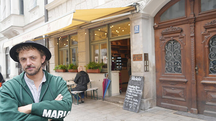 Fabian Stingl vor dem Alof. Gesucht werden hier Mitarbeiter in der Küche und im Service. Die Bäckerei mit angeschlossenem Café hat günstige Brezen, vegane und nicht-vegane Kuchen und diverses Frühstück im Angebot.