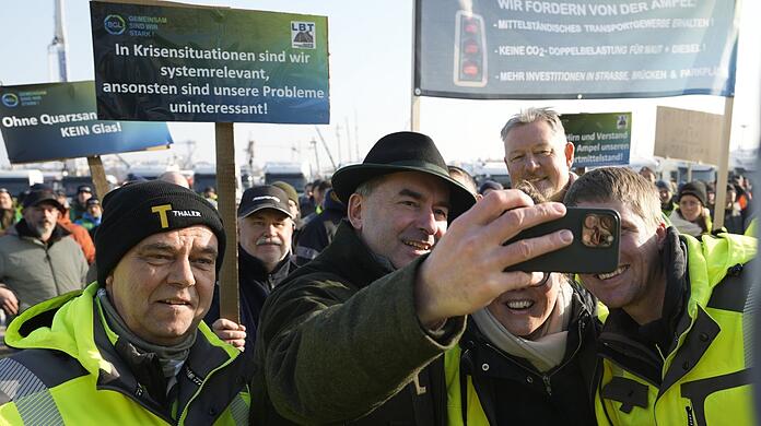 Vize-Ministerpräsident Hubert Aiwanger (FW) nimmt ein Selfie-Bad in der LKW-Fahrer-Menge auf der Theresienwiese.